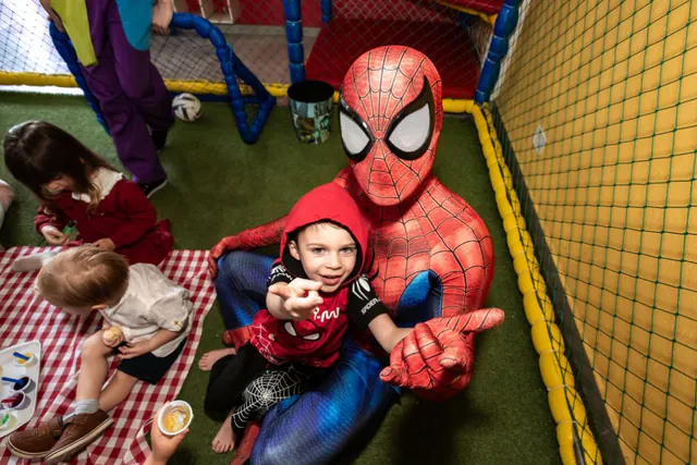 Tema Homem-Aranha: menino fantasiado brincando com o herói no playground