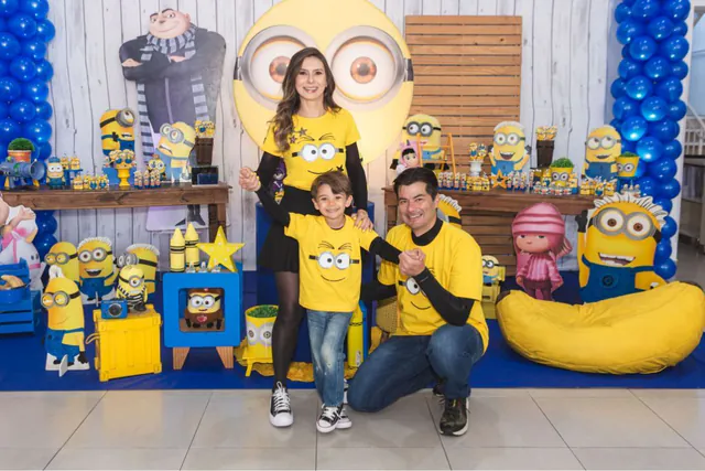 Tema Minions: família com camisetas amarelas em frente à decoração