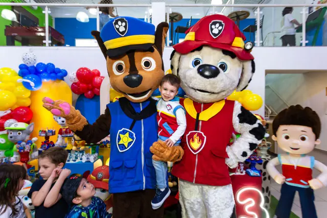 Criança no colo dos personagens da Patrulha Canina