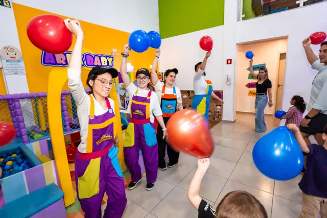 Monitoras da recreação brincando com as crianças e balões coloridos